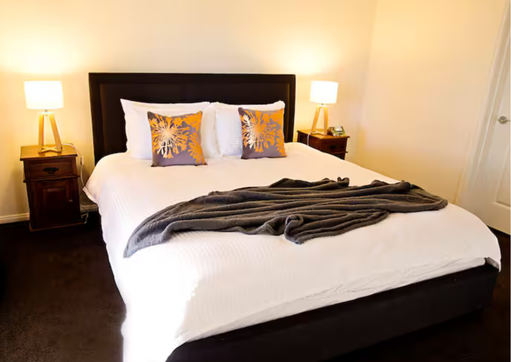 The spacious main bathroom with a modern vanity, separate glass shower, and a deep soaking bathtub.