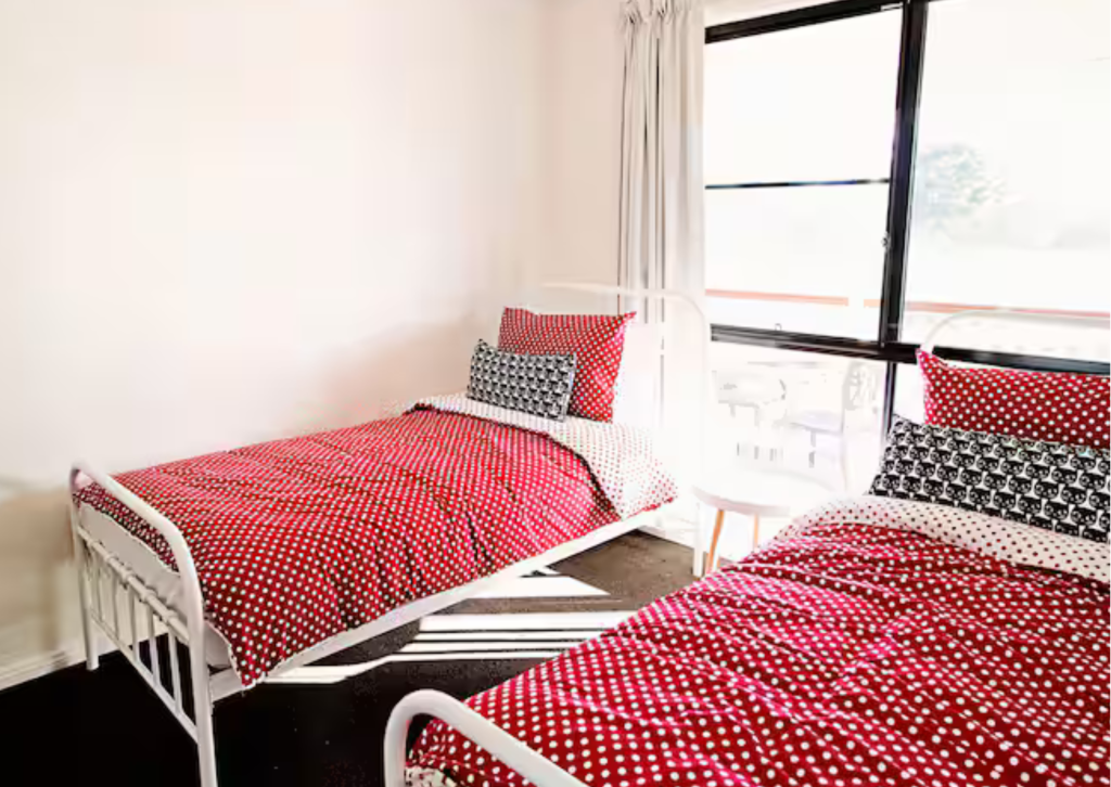 The fourth bedroom at The Homestead, featuring two comfortable single beds and bushland views.